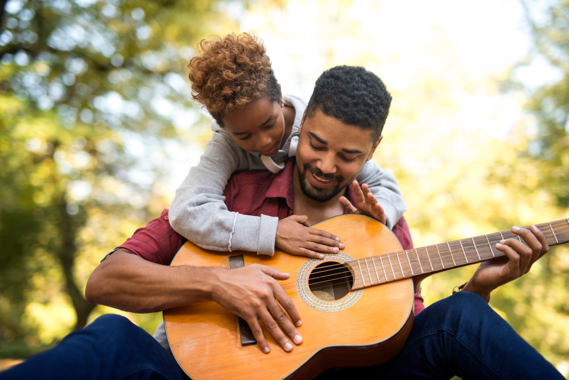 Man with child playing guitar 